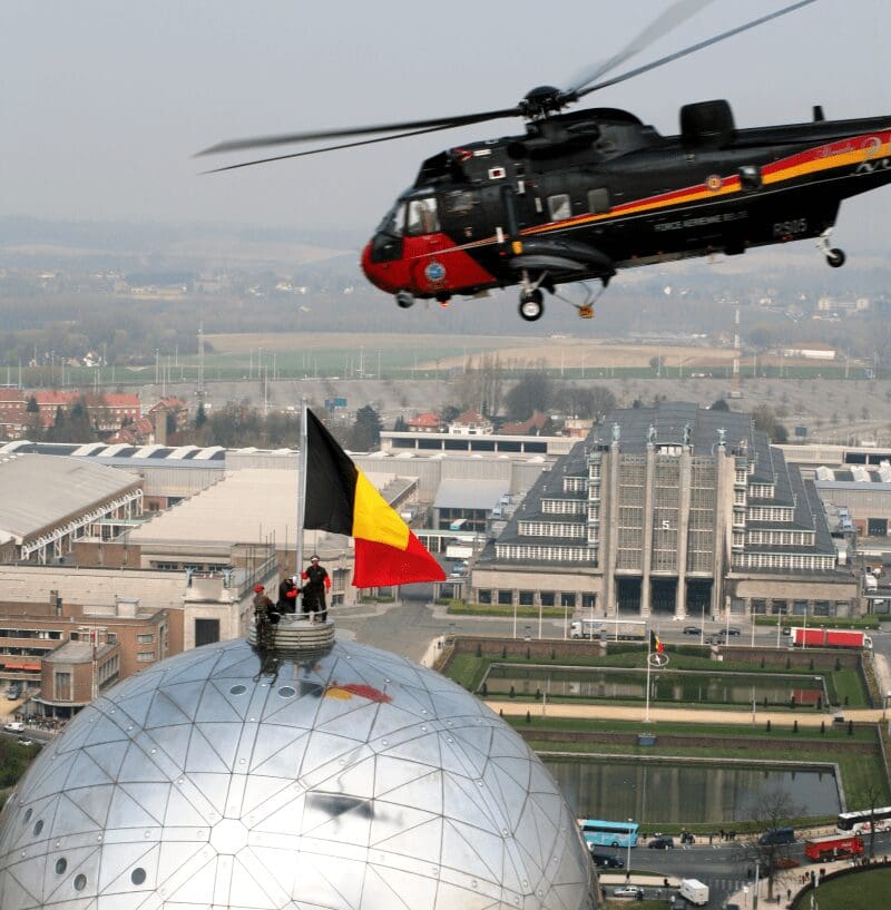 Herva plaatst de Belgische vlag op het atomium
